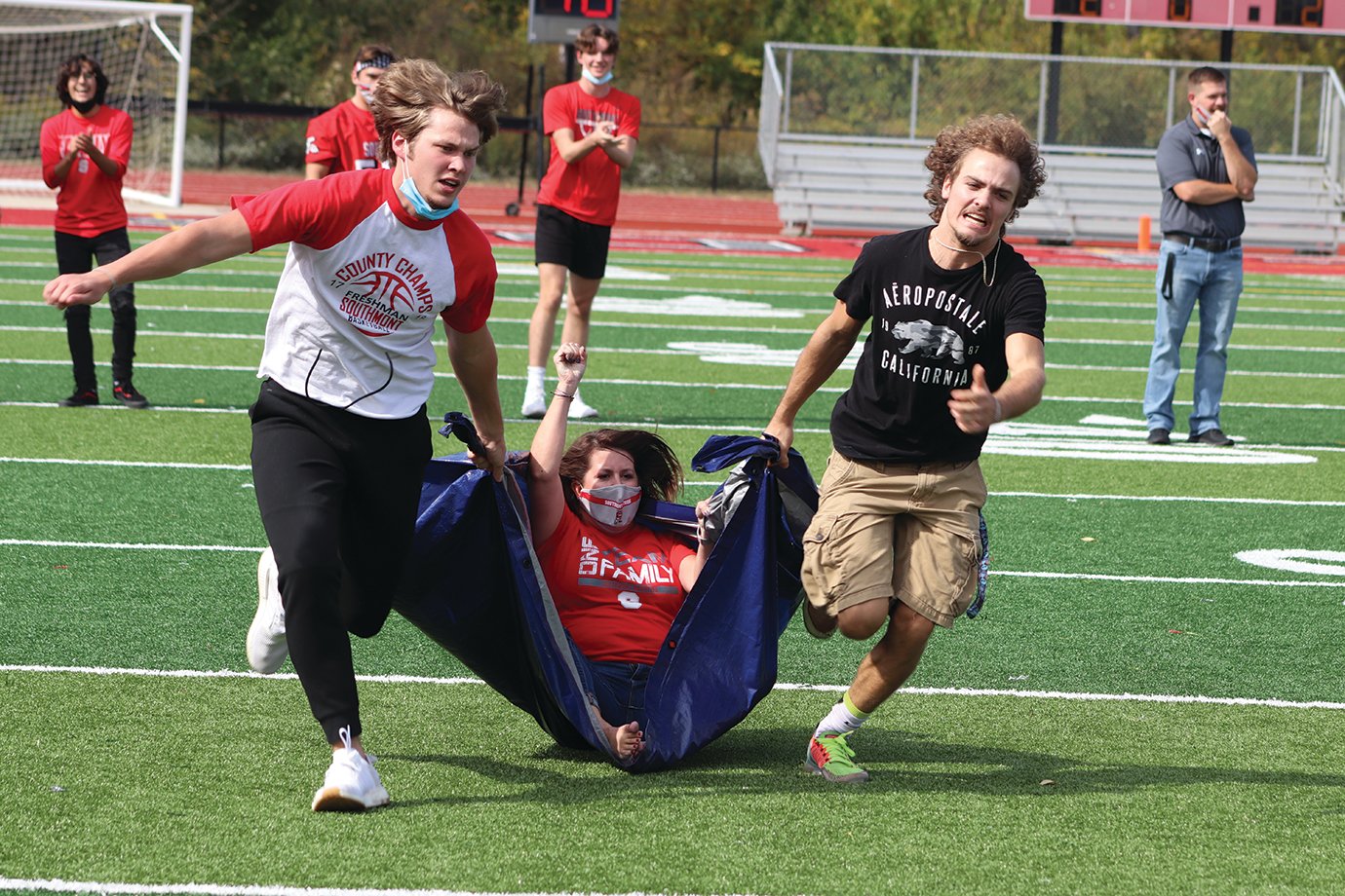 High school teacher Melissa Norman is dragged downfield by two Southmont seniors in a relay race between classes.